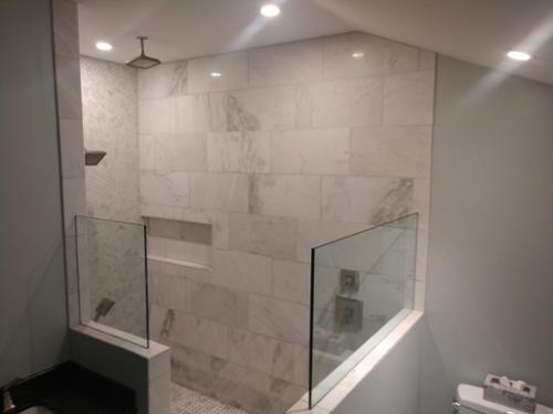 Over sized shower, Marble tile, 3 shower heads and custom glass.